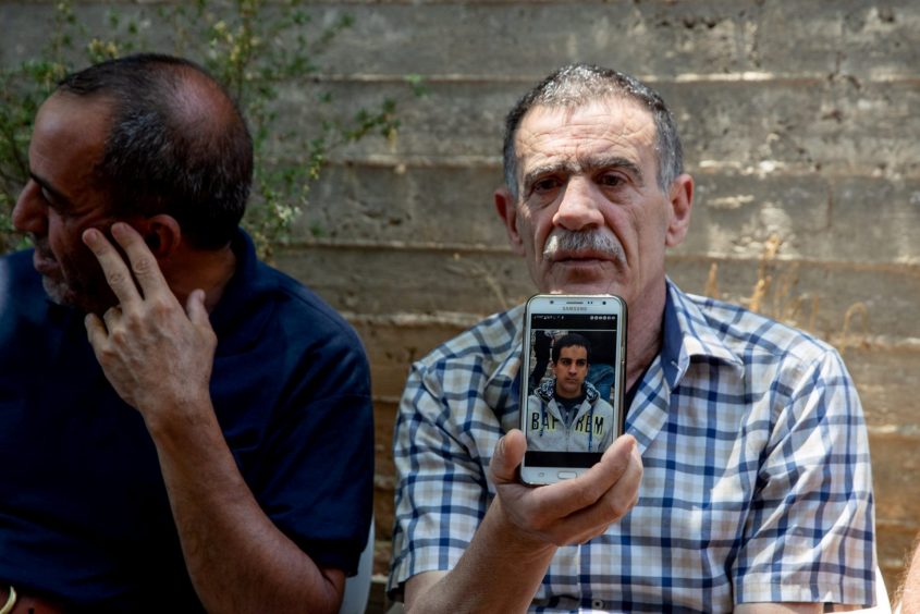 אביו של איאד אלחאלק עם תמונת בנו המנוח. צילום: אוהד צויגנברג