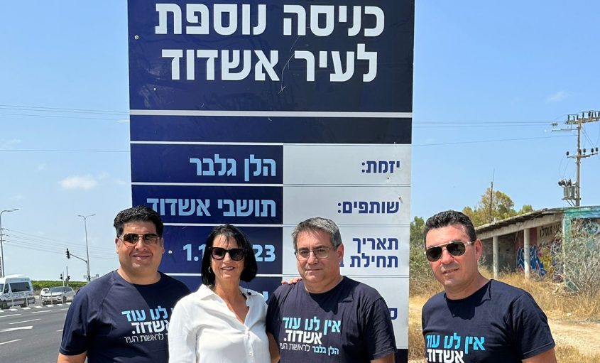 הלן גלבר ותומכים ליד השלט שתלתה בצומת אמונים