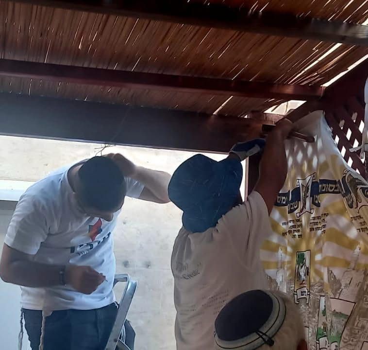 בני נוער מסייעים בהקמת סוכה. צילום: יחצ