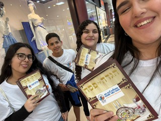 חלוקת הגדות פסח. צילום: מקס גלוקובסקי, מועצת הנוער